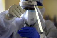 An Indian health worker wearing personnel protection kit (PPE) collects nasal swab samples in Gauhati, India, Saturday, July 4, 2020. India's number of coronavirus cases passed 600,000 on Thursday with the nation's infection curve rising and its testing capacity being increased. More than 60% of the cases are in the worst-hit Maharashtra state, Tamil Nadu state, and the capital territory of New Delhi. (AP Photo/Anupam Nath)