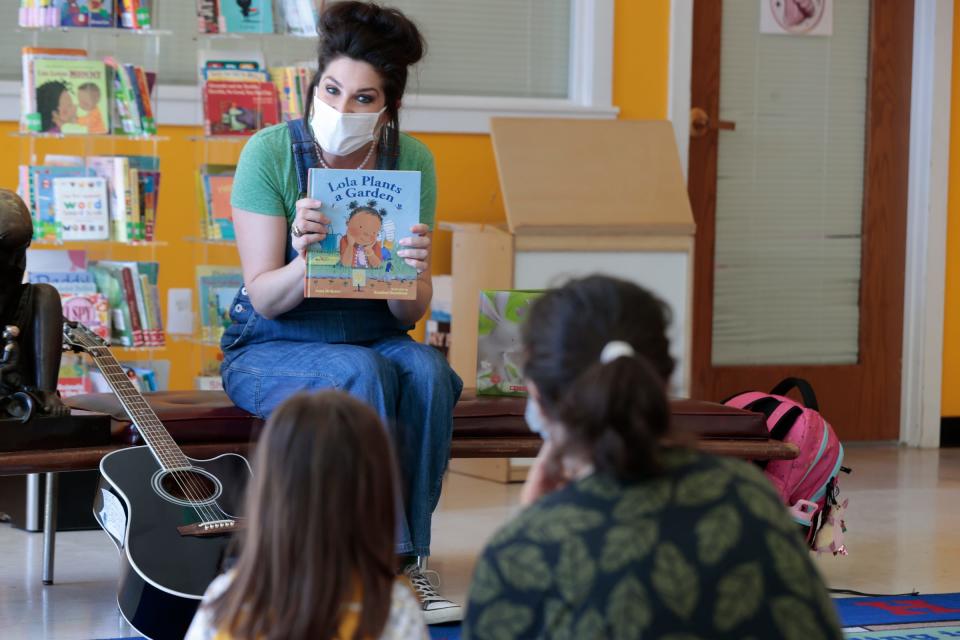 Danielle Carlomusto, 44, of Grosse Pointe Woods, finishes reading a book to kids before singing a song to them at her Gro-Town event in the children’s library at the main branch of the Detroit Public Library on Woodward Avenue in Detroit on Thursday, April 13, 2023. Carlomusto’s program teaches kids about seeds and planting in order to feel connected with the earth and doing outside things with family.