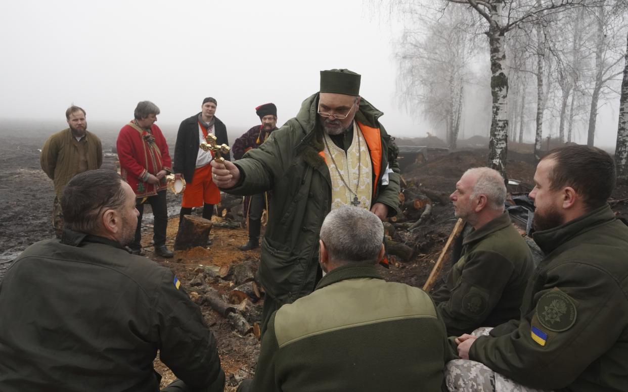 A chaplain blesses Ukraine's National Guard soldiers to mark Christmas at their positions close to the Russian border near Kharkiv, Ukraine, Saturday, Dec. 24 2022. (AP Photo/Andrii Marienko)