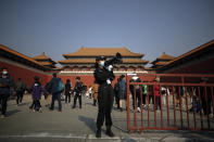 A security guard uses a loud speaker to advise tourists to scan their health code before entering Forbidden City in Beijing, Sunday, Oct. 25, 2020. With the outbreak of COVID-19 largely under control within China's borders, the routines of normal daily life have begun to return for its citizens. (AP Photo/Andy Wong)