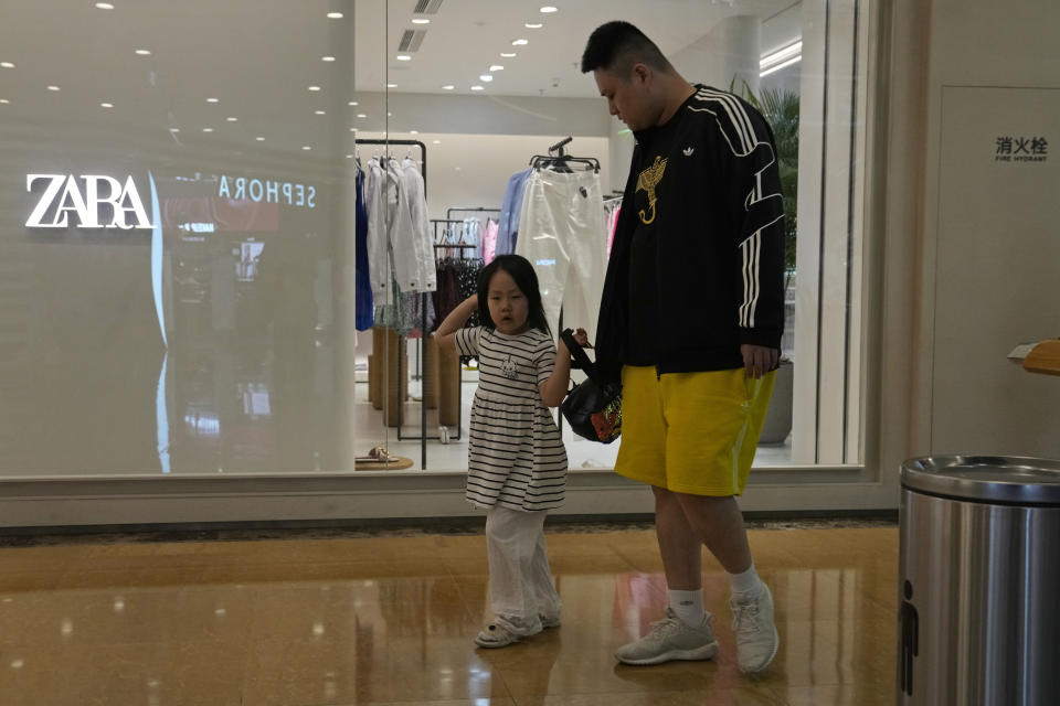 A man and child pass by a Zara store in Beijing on Thursday, June 3, 2021. The Chinese government has accused H&M, Nike, Zara and other brands of importing unsafe or poor quality children's clothes and other goods, adding to headaches for foreign companies after Beijing attacked them over complaints about possible forced labor in the country's northwest. (AP Photo/Ng Han Guan)