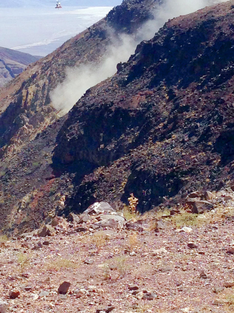 This photo provided by Panamint Springs Resort shows where a Navy fighter jet crashed Wednesday, July 31, 2019, in Death Valley National Park, injuring several people who were at a scenic overlook where aviation enthusiasts routinely watch military pilots speeding low through a chasm dubbed Star Wars Canyon, officials said. The crash sent dark smoke billowing in the air, said Aaron Cassell, who was working at his family's Panamint Springs Resort about 10 miles (16 kilometers) away. (Aaron Cassell/Panamint Springs Resort via AP)