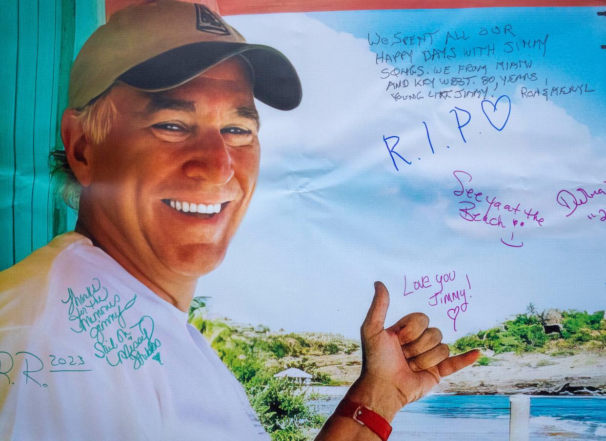 Fans signed a banner with a picture of Jimmy Buffet at "Clematis by Night Celebrates Jimmy Buffett."