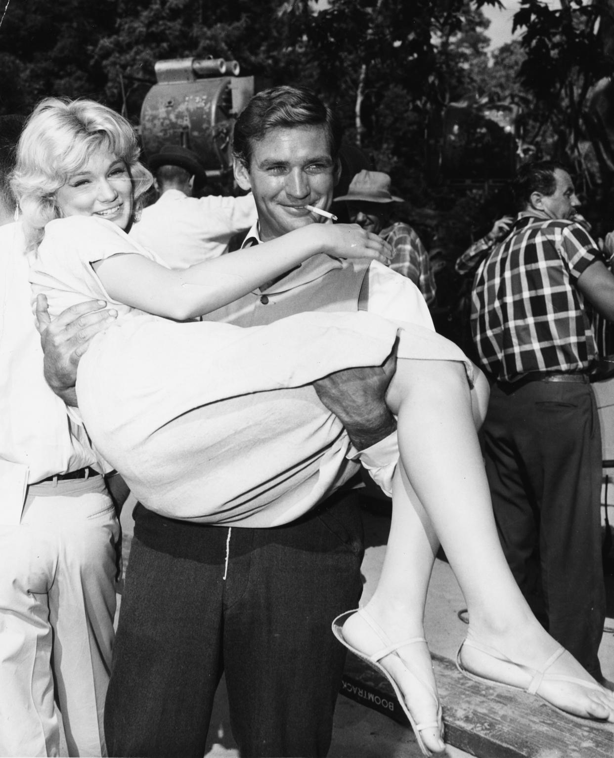 Actor Rod Taylor carrying Yvette Mimieux in his arms, circa 1960. The two starred in "The Time Machine" together.