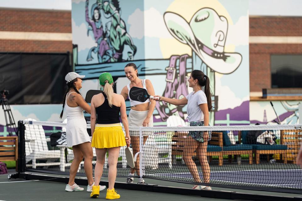 Players high five with their pickleball rackets after playing a game at the new Austin Pickle Ranch Wednesday, Sept. 27, 2023. The grand opening is on October 1.