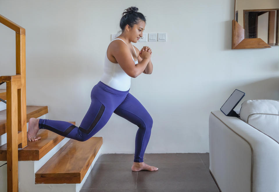 Woman doing lunges at home. (Getty Images)