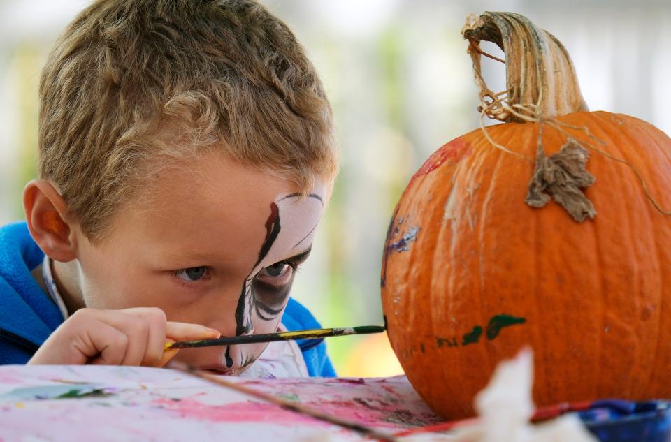 Rhett Schultz, 5, paints a pumpkin in 2022 in the Children's Garden area of the Myriad Botanical Gardens.