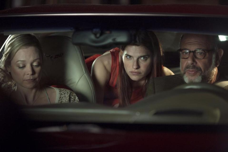 Three people sitting in a dark car