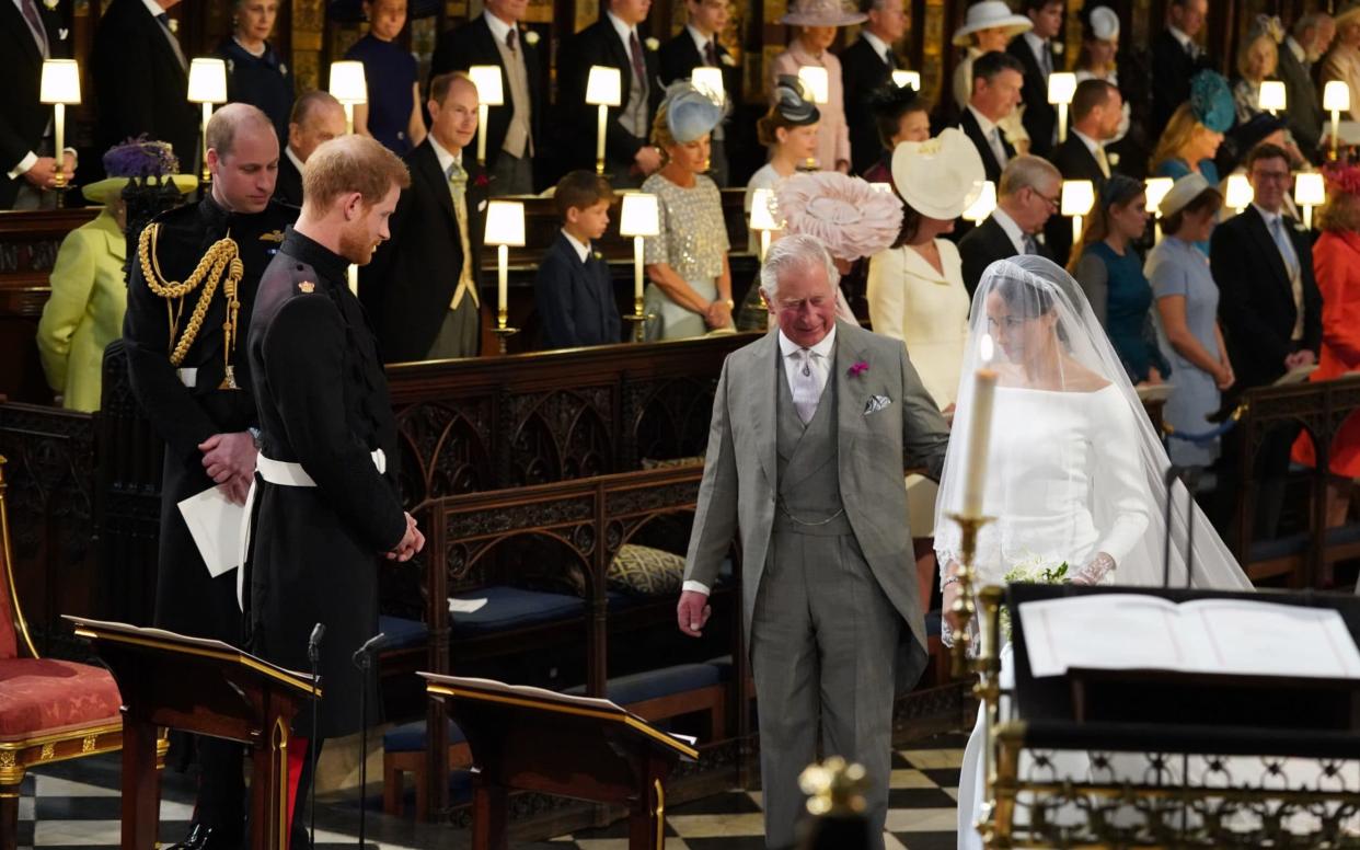 Prince Harry looks at his bride, Meghan Markle, as she arrives accompanied by the Prince of Wales - PA