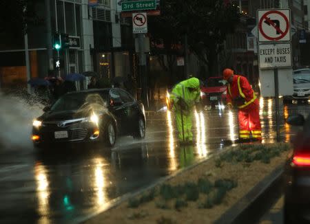 A work crew tends to a flooded intersection in San Francisco, California December 11, 2014. REUTERS/Robert Galbraith