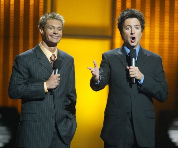 Ryan Seacrest and Brian Dunkleman speak onstage during the "American Idol in Vegas" concert on September 18, 2002