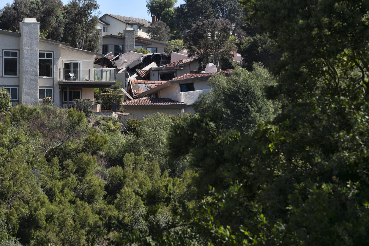 Homes in Southern California's Palos Verdes Peninsula are seen torn apart by earth movement in Rolling Hills Estates, Calif. on Monday, July 10, 2023. A dozen homes torn apart by earth movement during the weekend are likely to fall into an adjacent canyon. The homes in the Los Angeles County city of Rolling Hills Estates were hastily evacuated by firefighters Saturday when cracks began appearing in structures and the ground. (AP Photo/Richard Vogel)