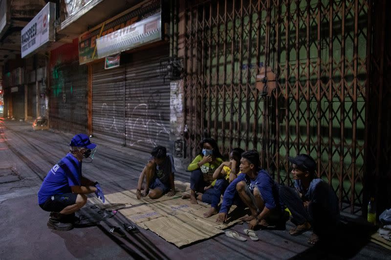 The Wider Image: Hazmat suits and holy water: two priests bring faith to Philippines lockdown