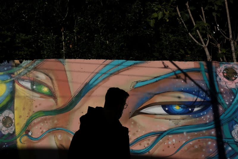 A person walks past an art mural in downtown Lisbon
