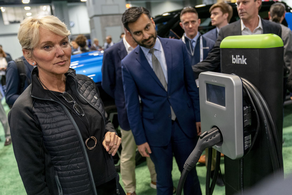 Energy Secretary Jennifer Granholm, left, and and White House national climate adviser Ali Zaidi, center, look at a charging station from blink during a visit to the Washington Auto Show in Washington, Wednesday, Jan. 25, 2023. (AP Photo/Andrew Harnik)