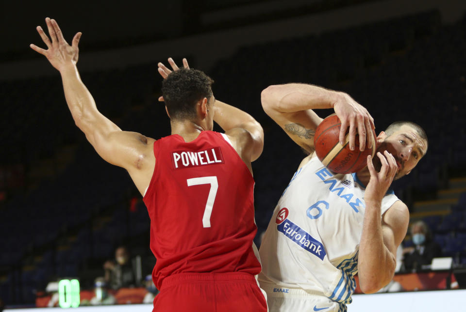 Canada's Dwight Powell tries to block Greece's Vassilis Kavvadas during the first half of a FIBA men's Olympic qualifying basketball game Tuesday, June 29, 2021 at Memorial Arena in Victoria, British Columbia. (Chad Hipolito/The Canadian Press via AP)