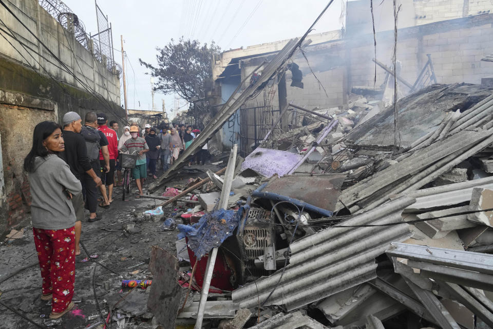 People examine the damaged at a neighborhood affected by a fuel depot fire in Jakarta, Indonesia, Saturday, March 4, 2023. A large fire broke out at the fuel storage depot in Indonesia's capital Friday, killing multiple people, injuring dozens of others and forcing the evacuation of thousands of nearby residents after spreading to their neighborhood, officials said. (AP Photo/Tatan Syuflana)