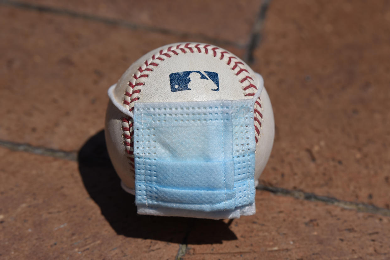 A baseball with a surgical mask placed on it.