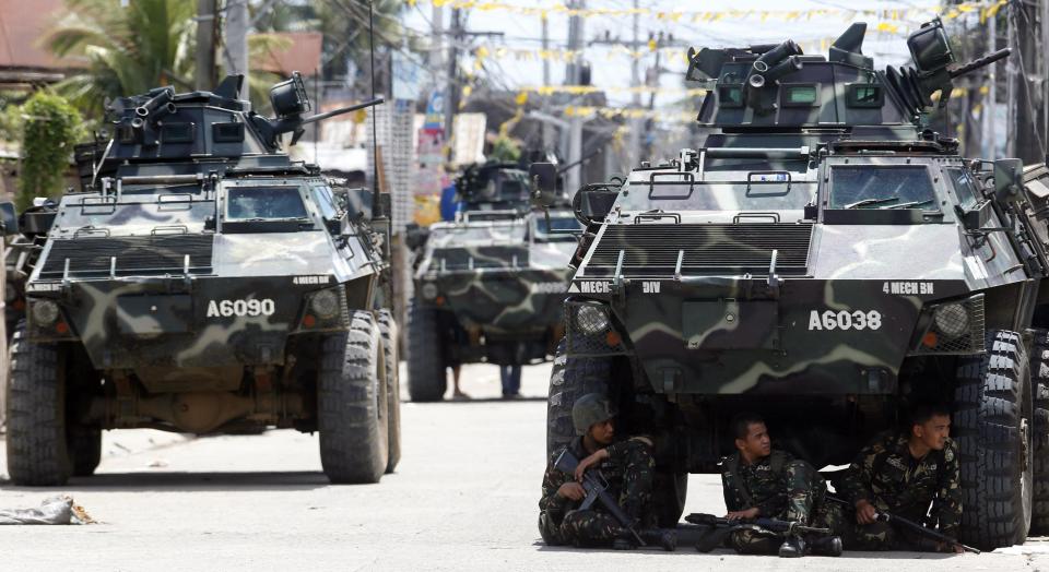 Government soldiers rest under an armoured vehicle during a lull in their operation against the Muslim rebels in Zamboanga city, in southern Philippines September 11, 2013. Moro National Liberation Front gunmen, seeking to declare an independent state, put a dozen civilians tied together on display as a human shield on Wednesday as a standoff with security forces here entered its third day. (REUTERS/Erik De Castro)