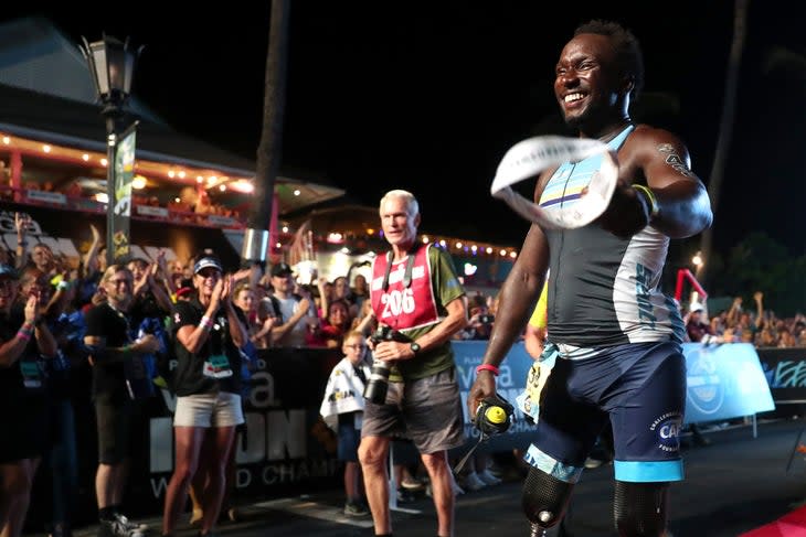 An athlete smiles as he makes his way through the crowd at Ironman Kona Alii Drive