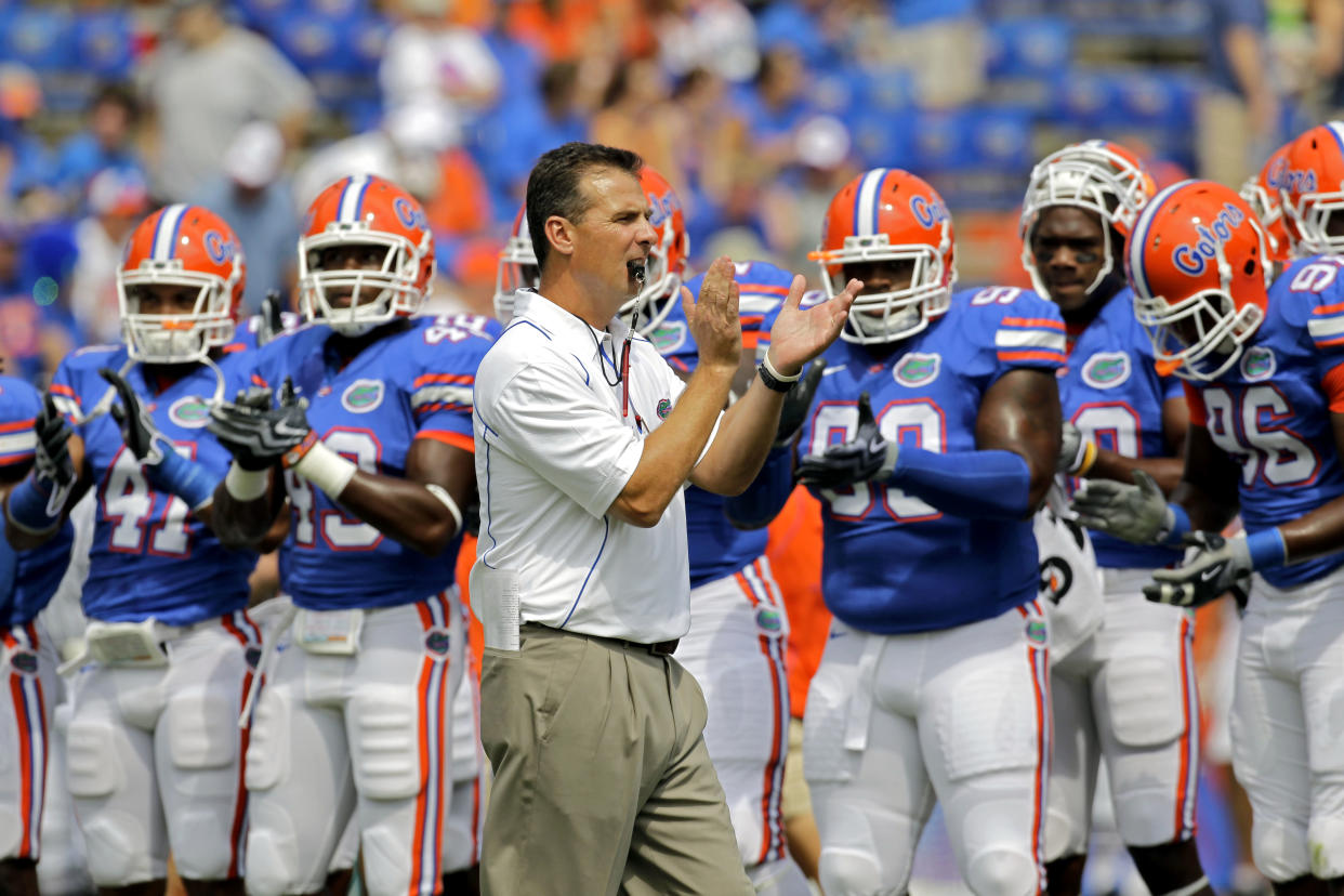 Florida head coach Urban Meyer, center, encourages his players before an NCAA college football game against Miami (Ohio) in Gainesville, Fla., Saturday, Sept. 4, 2010. (AP Photo/John Raoux)