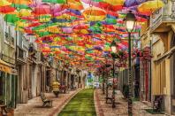 Águeda's Umbrella Sky Project began in 2011 as a part of the Portuguese city's annual Ágitagueda Art Festival. Each summer, when temperatures soar, a handful of Águeda's narrow streets feature canopies of colorful umbrellas that provide shade to the pedestrians below.