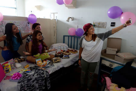 Lismar Castellanos, 21, who lost her transplanted kidney, poses for a selfie with her mother and friends during her birthday celebration at a state hospital in Caracas, Venezuela February 7, 2018. REUTERS/Carlos Garcia Rawlins