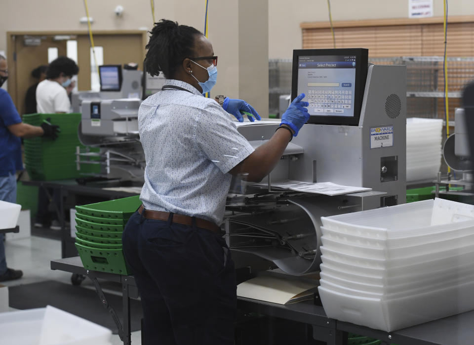 FORT LAUDERDALE, FL - NOVEMBER 03: Election workers are seen loading ballots into the vote counting machine on election day 2020 at the Broward County Supervisor of Elections office during the 2020 Presidential Election on November 3, 2020 in Fort Lauderdale, Florida. Credit:mpi04/MediaPunch /IPX