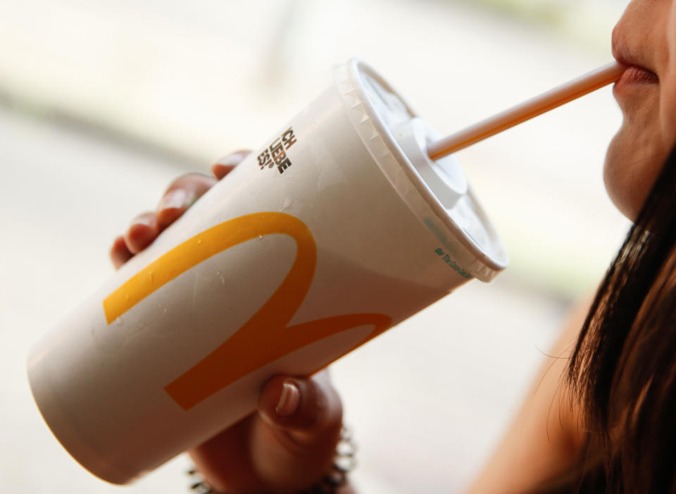 Woman drinks from McDonald's cup as coronavirus prevention methods employed in Australian stores