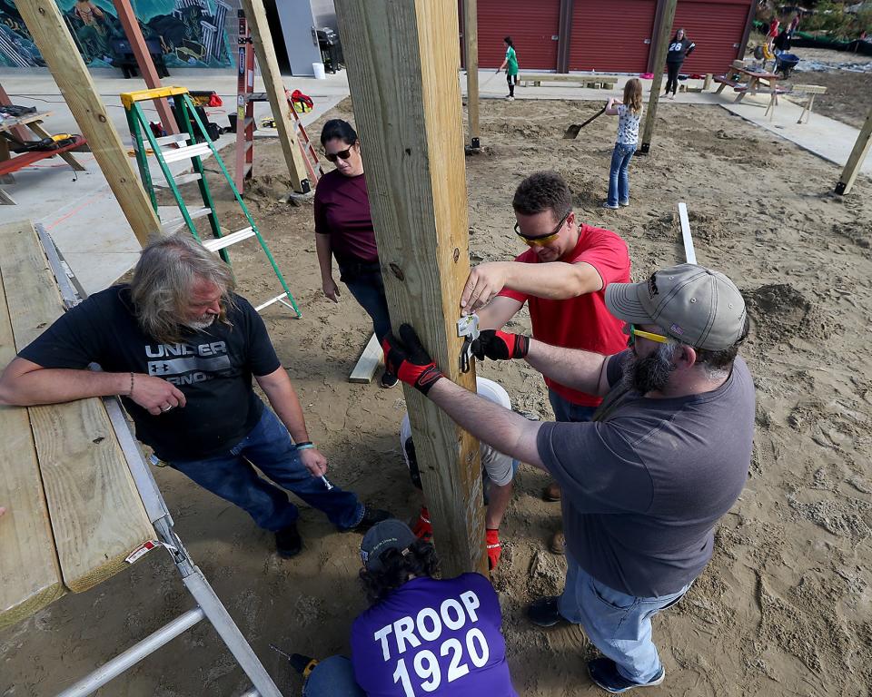 Nathaniel Budd and Tim Oliveira make sure the post is level while helping Nathaniel's daughter Alyssa with her Eagle Scout project at the Marshfield Boys and Girls Club on Saturday, Oct 15, 2022.