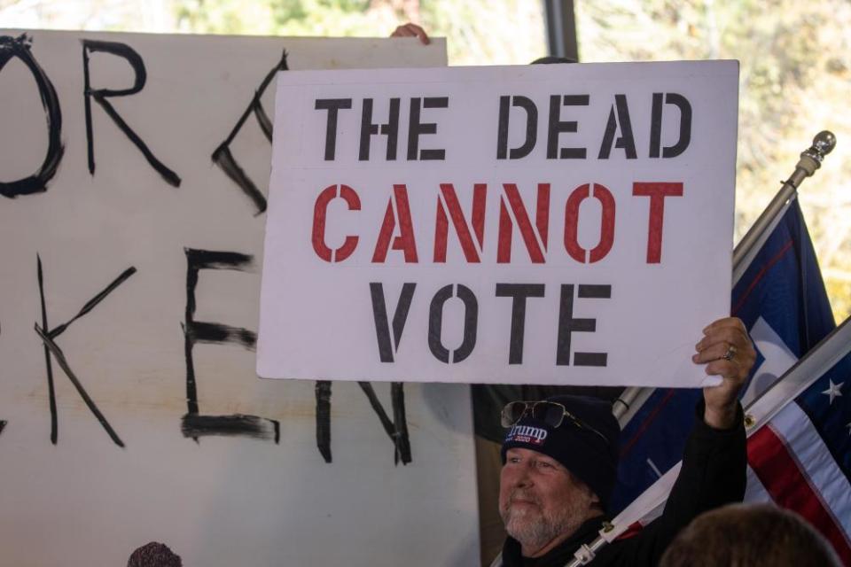 A man holds a sign reading 