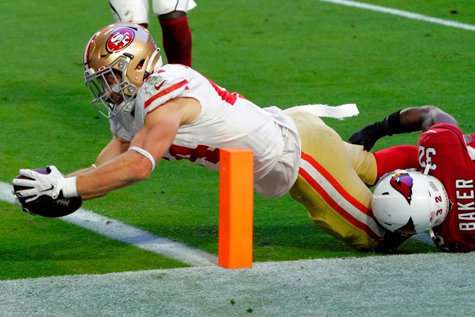 San Francisco 49ers fullback Kyle Juszczyk dives in for a touchdown as Arizona Cardinals strong safety Budda Baker (32) defends Dec. 26, 2020, in Glendale, Ariz.