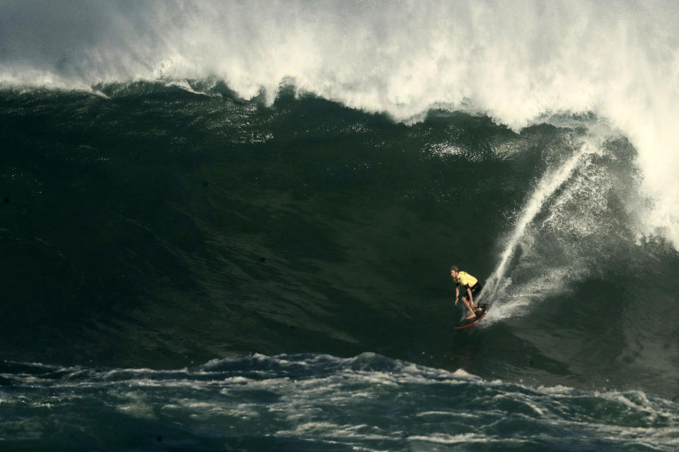 John John Florence, the reigning champion of The Eddie Aikau Big Wave Invitational surfing contest, takes off on his first wave of the day in Hawaii's Waimea Bay on Oahu’s North Shore during the The Eddie, Sunday, Jan. 22, 2023. (Jamm Aquino/Honolulu Star-Advertiser via AP)