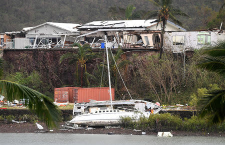 A damaged building is seen behind a boat that was pushed onto a bank in Airlie Beach. AAP/Dan Peled/via REUTERS