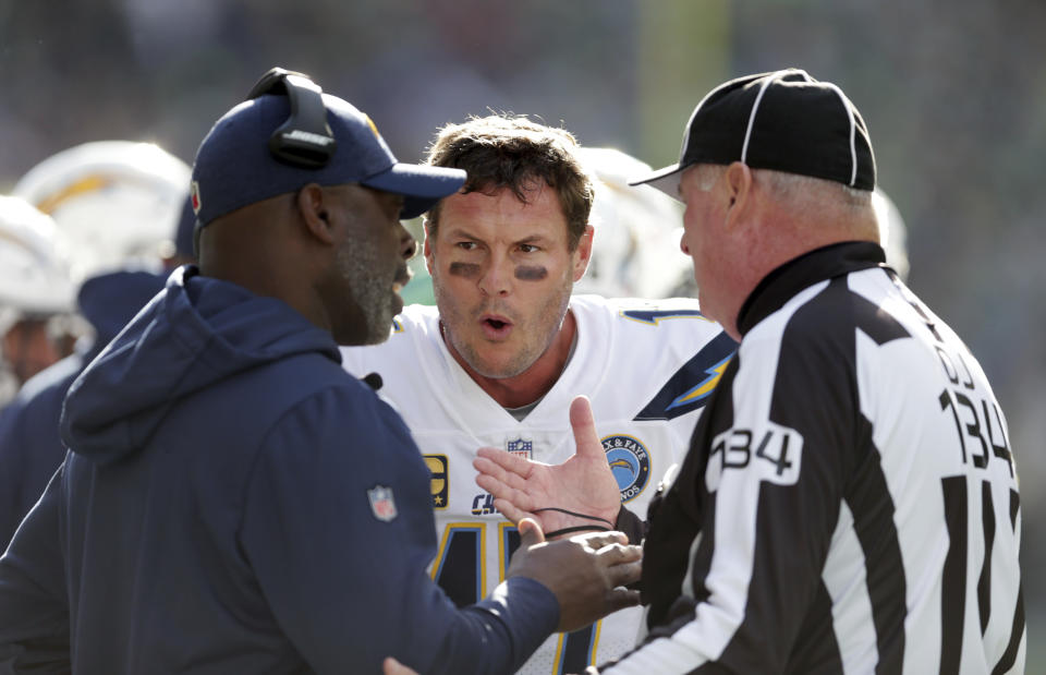 Los Angeles Chargers quarterback Philip Rivers, center, talks with head coach Anthony Lynn, left, and official Ed Camp during the first half of an NFL football game against the Seattle Seahawks, Sunday, Nov. 4, 2018, in Seattle. (AP Photo/Scott Eklund)