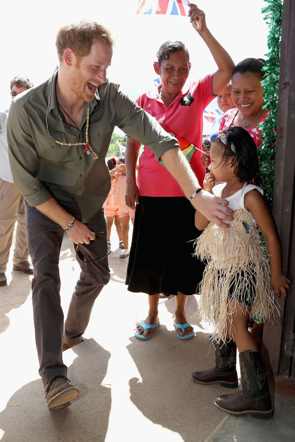 <p>During a trip to the Caribbean in 2016, Harry jokes around with a young girl.</p>