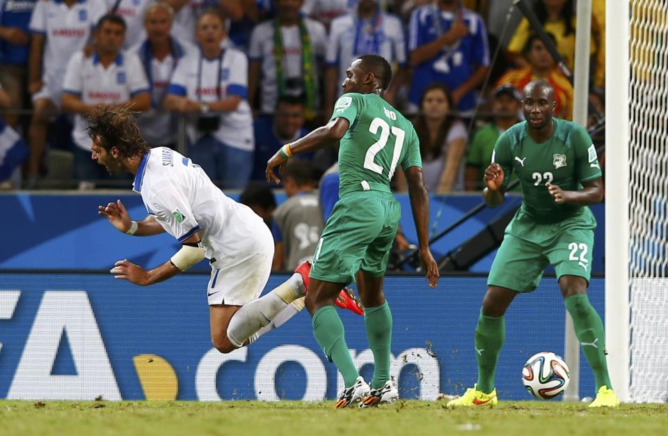 Ivory Coast's Giovanni Sio (C) commits a foul on Greece's Giorgios Samaras (L) during their 2014 World Cup Group C soccer match at the Castelao arena in Fortaleza June 24, 2014. Greece was awarded a penalty kick which they scored to win the match. REUTERS/Eddie Keogh (BRAZIL - Tags: SOCCER SPORT WORLD CUP TPX IMAGES OF THE DAY)