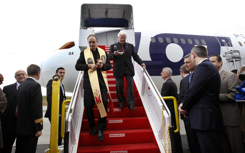 Fr. Stanislaw Michalek, left, walks down the boarding stairs to a LOT Polish Airlines Boeing 787 with Marian Strutynski after Michalek blessed the aircraft during a delivery ceremony Wednesday, Nov. 14, 2012, at Paine Field in Everett, Wash. LOT Polish Airlines took delivery of its first Boeing 787 and plans to fly early next year on routes between Poland and New York, Chicago and Toronto. Poland's LOT was Europe's first airline to purchase the new plane with an order for eight. Boeing says the 787 is the first mid-size plane capable of flying long-range routes, allowing airlines to open new, non-stop flights. (AP Photo/Elaine Thompson)