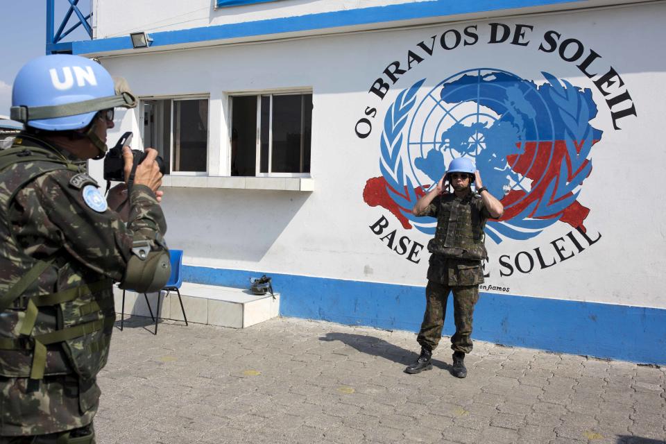 In this Feb. 22, 2017 photo, a U.N. peacekeeper from Brazil poses for a souvenir photo before the start of a patrol in the Cite Soleil slum, in Port-au-Prince, Haiti. With a steady downsizing of Haiti peacekeeping operations in recent years and the U.S. administration of President Donald Trump pushing for cutbacks, the U.N. is looking at sending home more than 2,000 troops from contributing countries. (AP Photo/Dieu Nalio Chery)