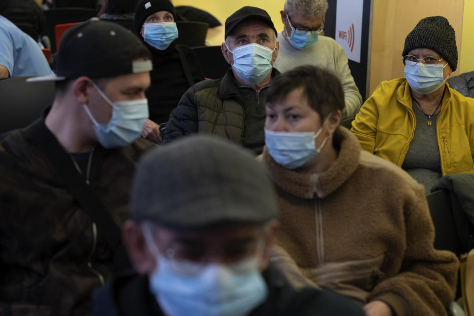 People wearing face masks as a precaution wait for a doctor appointment inside a hospital in Barcelona, Spain, Monday, Jan. 8, 2024. Regional and national health chiefs are meeting Monday to decide whether to extend mandatory mask—wearing to all health facilities following an epidemic outbreak of flu and other respiratory viruses that are putting a strain on the system. (AP Photo/Emilio Morenatti)