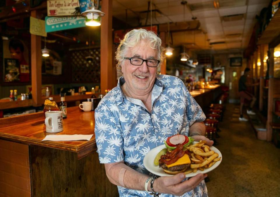 Walter 'Wally' Muench, dueño del restaurante Wagons West, preparó una hamburguesa con queso y tocino en su restaurante el viernes 1º de julio de 2022, en Pinecrest, Florida.