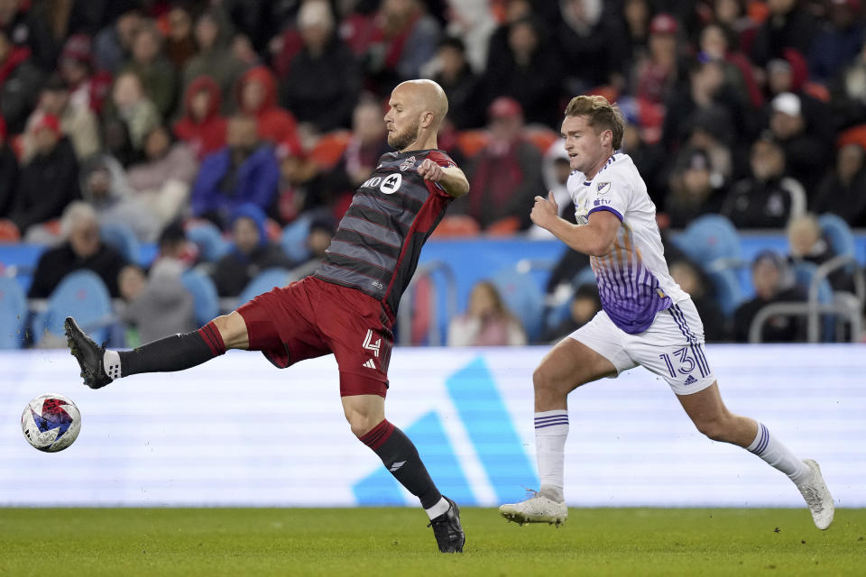 Toronto FC midfielder Michael Bradley (4) vies for the ball against Orlando City forward Duncan McGuire (13) during the second half of an MLS soccer match in Toronto on Saturday, Oct. 21, 2023. (Nathan Denette/The Canadian Press via AP)