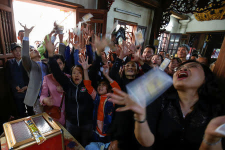 People react to bank notes being thrown during a ritual Hau Dong ceremony at Lanh Giang temple in Ha Nam province, Vietnam, March 26, 2017. REUTERS/Kham