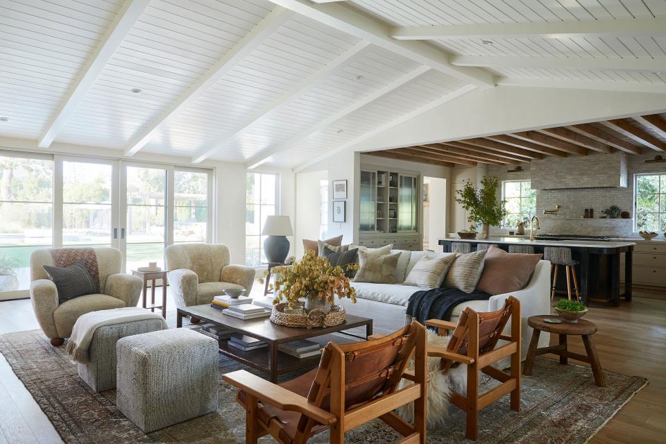 Guests are welcomed by an assortment of comfortable seating in the living room. “I wanted it to feel conversational,” says Lewis. “There are only so many butts you can fit on a sofa comfortably, even if it’s 10 feet long.” Lewis sourced the tonal Carpenter slipcovered couch and fuzzy namesake Lewis armchairs from her Shoppe and added vintage leather Borge Mogensen Spanish hunting chairs too. Her rule of thumb for the ceilings? “If flat, it gets reclaimed wood,” explains Lewis. “If vaulted, it gets tongue-and-groove beams. They help draw the eye up and add another layer to make the house feel done.”