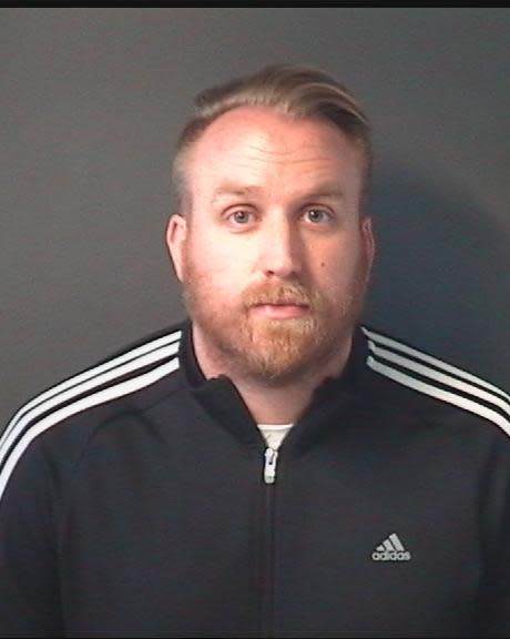 A mugshot of Sean Aldridge wearing a black Adidas tracksuit.