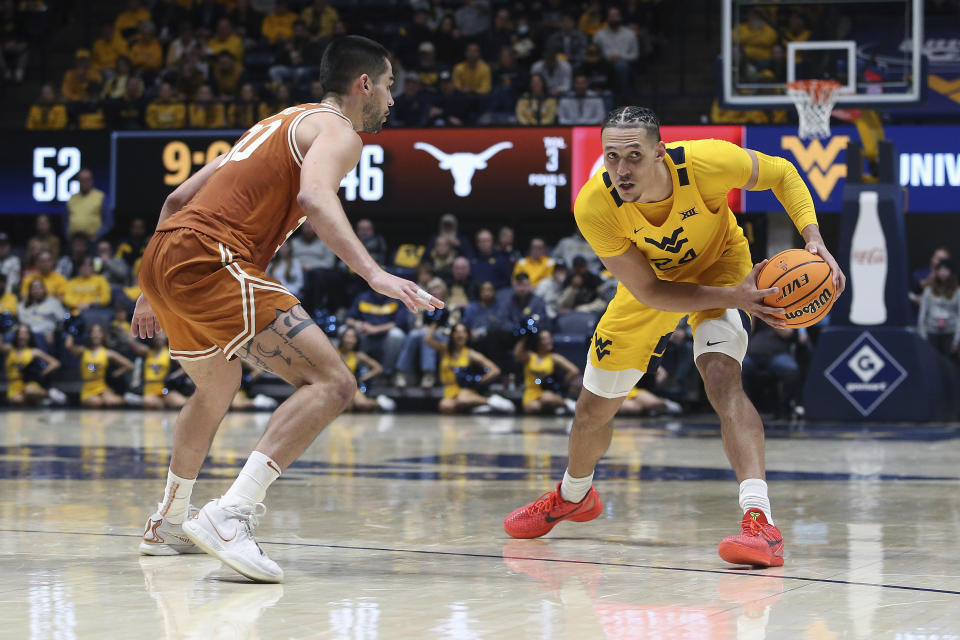 West Virginia forward Patrick Suemnick (24) is defended by Texas forward Brock Cunningham (30) during the second half of an NCAA college basketball game on Saturday, Jan. 13, 2024, in Morgantown, W.Va. (AP Photo/Kathleen Batten)