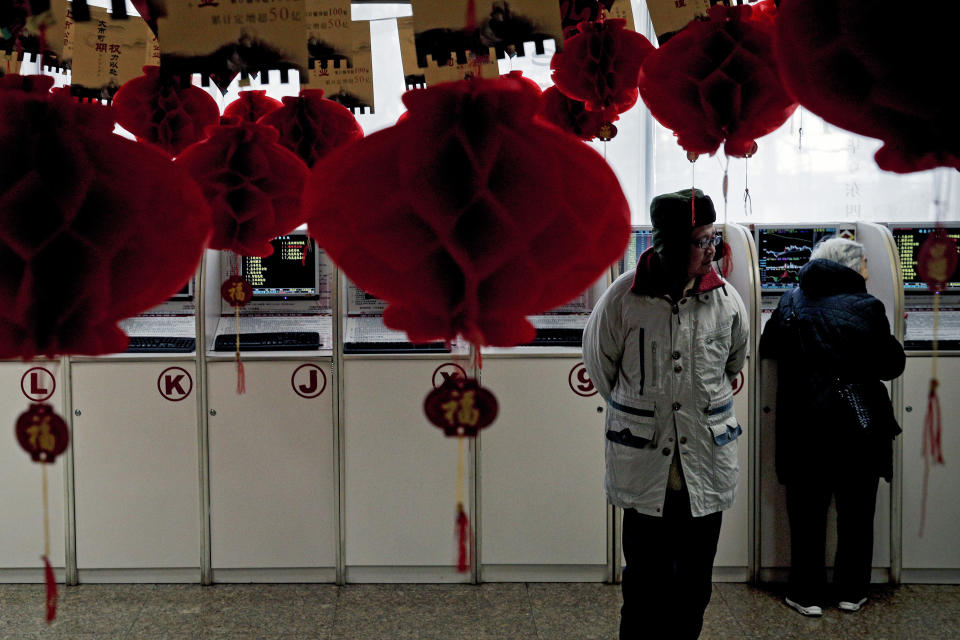 Investors check stock prices at a brokerage house decorated with red lanterns in Beijing, Friday, Feb. 1, 2019. Asian markets were mixed on Friday as trade talks ended in Washington with no deal but the promise of a second meeting between U.S. President Donald Trump and Chinese leader Xi Jinping. Gains were limited by a private survey showing that Chinese manufacturing slowed to the lowest level in almost three years. (AP Photo/Andy Wong)