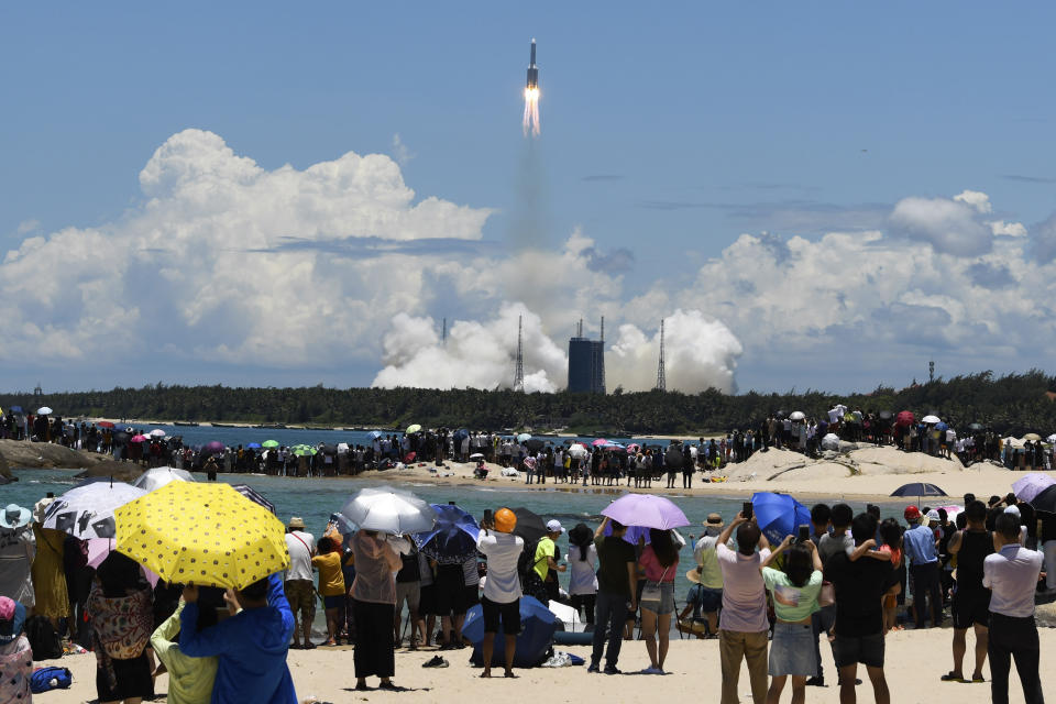 FILE - In this Thursday, July 23, 2020 photo released by China's Xinhua News Agency, spectators watch as a Long March-5 rocket carrying the Tianwen-1 Mars probe lifts off from the Wenchang Space Launch Center in southern China's Hainan Province. (Yang Guanyu/Xinhua via AP)