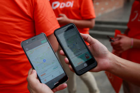 An employee shows the app of China's Didi Chuxing as they launches their ride service in Toluca, Mexico, April 23, 2018. REUTERS/Carlos Jasso