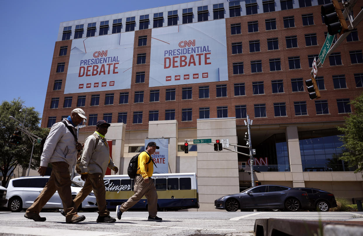  Pedestrians walk past CNN signage ahead of June 27 debate. 